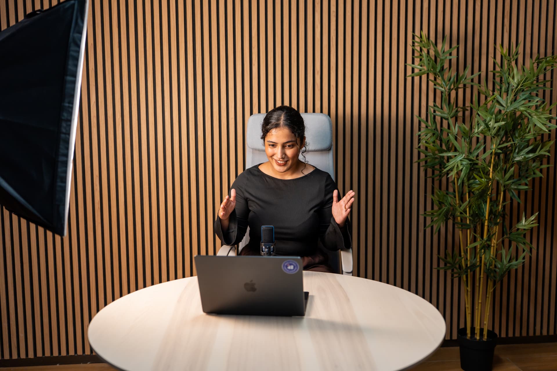 Tarannum recording a session at her desk with a mic and laptop